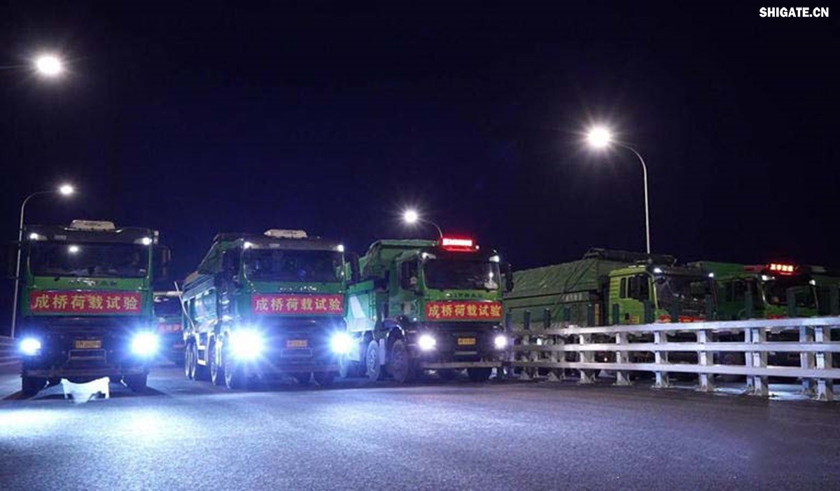 6月16日22時(shí)，世界最大跨度斜拉橋——常泰長(zhǎng)江大橋燈火通明，車聲轟鳴，一場(chǎng)通車前的“極限挑戰(zhàn)”正緊張進(jìn)行。30輛總重達(dá)1200噸的四軸加載車，分批列隊(duì)駛上橋面預(yù)先劃定的?？奎c(diǎn)，并由提前布置在橋梁各關(guān)鍵部位的869個(gè)傳感器開展實(shí)時(shí)監(jiān)測(cè)，采集測(cè)試數(shù)據(jù)。由此，大橋跨江公鐵合建段主橋橋梁荷載試驗(yàn)全面啟動(dòng)。    AA1GQ79M.jpg    這次荷載試驗(yàn)覆蓋范圍具體包括1座主跨1208米斜拉橋、2座主跨388米鋼桁拱專用航道橋、1座非通航道孔橋以及南北兩座引橋，共設(shè)計(jì)119個(gè)靜載工況和111個(gè)動(dòng)載工況。其中，最大對(duì)稱靜力加載工況將動(dòng)用110輛四軸加載車，總重達(dá)4400噸。試驗(yàn)將持續(xù)一周，分五個(gè)階段進(jìn)行。試驗(yàn)首日在錄安洲非通航孔橋和常州側(cè)公鐵合建段引橋?qū)嵤? 常泰長(zhǎng)江大橋是連通常州與泰興的跨江通道，是長(zhǎng)江上首座集高速公路、城際鐵路和普通公路三種功能于一體的雙層復(fù)合型橋梁，計(jì)劃于今年年內(nèi)基本建成。它的上層為雙向六車道高速公路，下層為雙線城際鐵路和普通公路。如此復(fù)雜的結(jié)構(gòu)，如何確保它在未來(lái)百年服役中安全可靠？答案就藏在荷載試驗(yàn)中。    AA1GQduQ.jpg    荷載試驗(yàn)堪稱橋梁通車前的“綜合大考”，是確保橋梁安全運(yùn)營(yíng)的“體檢報(bào)告”。江蘇省交通工程建設(shè)局常泰長(zhǎng)江大橋建設(shè)指揮部現(xiàn)場(chǎng)常務(wù)副指揮長(zhǎng)夏鵬飛介紹，“荷載試驗(yàn)是檢測(cè)橋梁結(jié)構(gòu)安全和承載能力的重要手段，通過(guò)科學(xué)的加載測(cè)試和數(shù)據(jù)采集分析，驗(yàn)證實(shí)際成橋狀態(tài)與理論設(shè)計(jì)的鍥合度，確保常泰長(zhǎng)江大橋運(yùn)營(yíng)安全?！笨紤]到大橋主體采用鋼結(jié)構(gòu)和鋼-混凝土組合結(jié)構(gòu)，為最大限度減少晝夜溫差對(duì)測(cè)試數(shù)據(jù)的影響，所有試驗(yàn)均安排在夜間實(shí)施。  通過(guò)一系列科學(xué)嚴(yán)謹(jǐn)?shù)暮奢d測(cè)試，這座世界級(jí)多功能大橋的實(shí)際性能將得到充分檢驗(yàn)，為常泰長(zhǎng)江大橋后續(xù)安全通車運(yùn)營(yíng)提供至關(guān)重要的數(shù)據(jù)支撐。